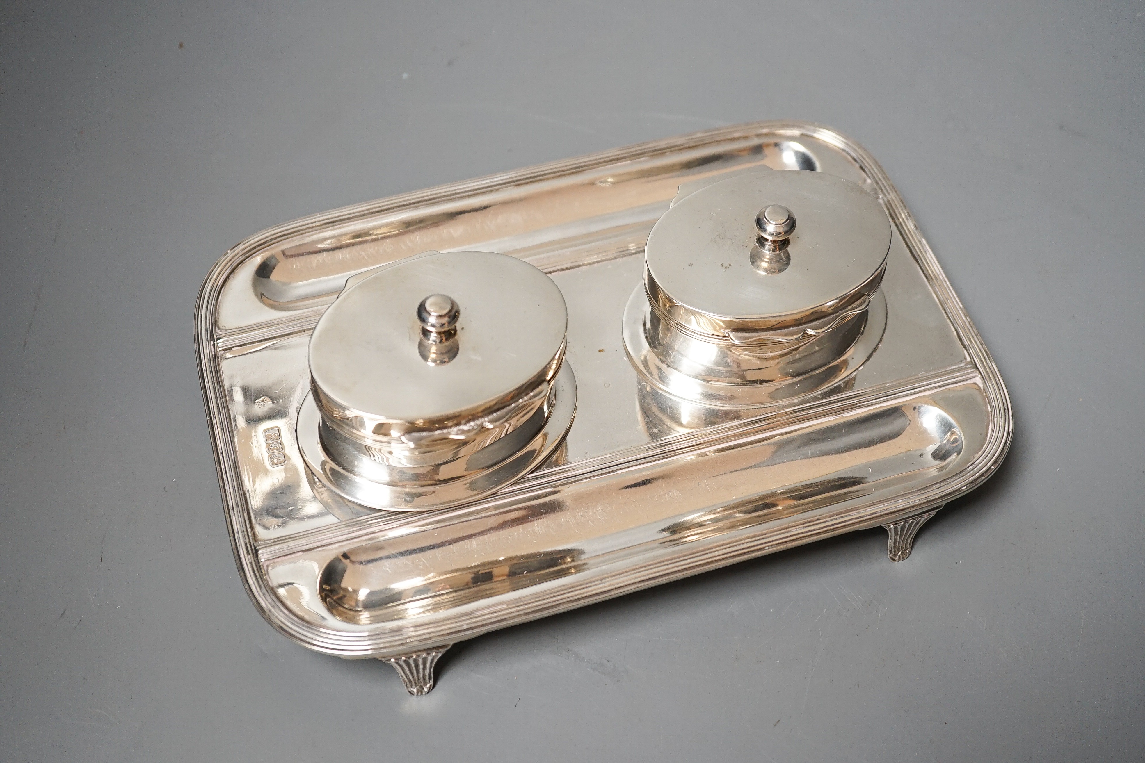 A late Victorian silver rounded rectangular inkstand, with two wells and two pen recesses, Charles Stuart Harris, London, 1900, 22.3cm, gross 20oz.